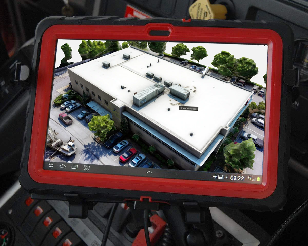 Mobile Dispatch Terminal mockup — a photogrammetry-captured building on the tablet already mounted in a fire truck cab.
